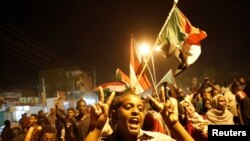 FILE - Protesters chant slogans and wave Sudanese flags during a rally in Khartoum, Sudan, June 21, 2019.