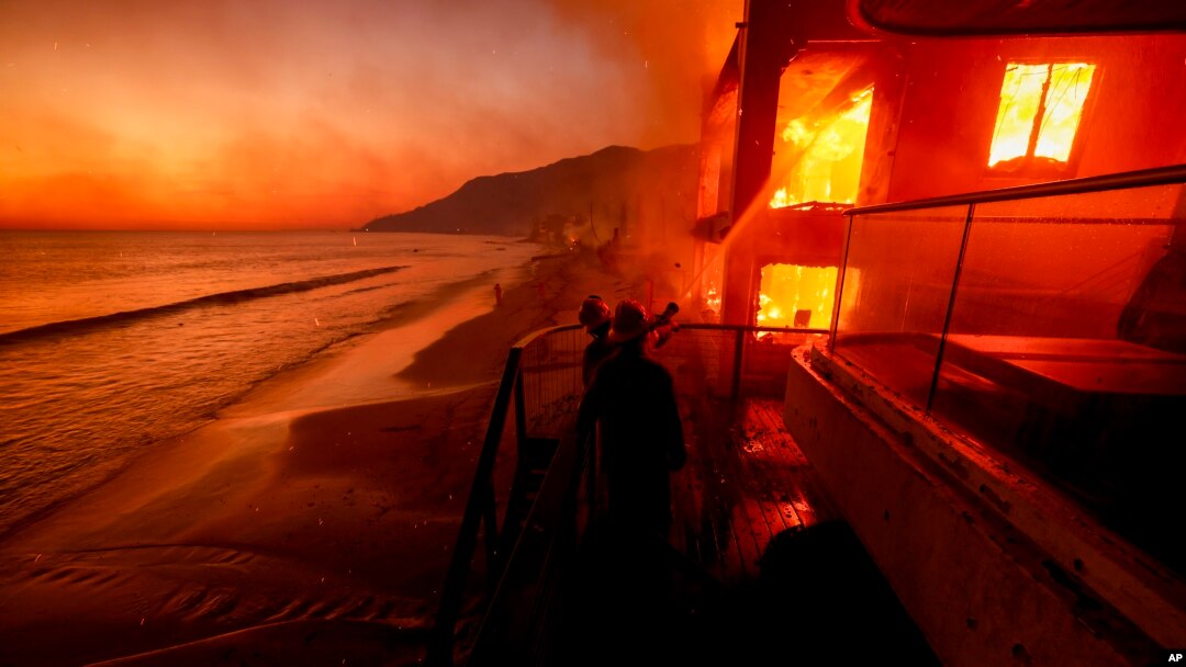 Ponpye travay pou eten dife ki pran nan yon kay nan Pacific Palisades, ki sitye bo lanme, nan Malibu, Kalifoni, 8 Janvye 2025.