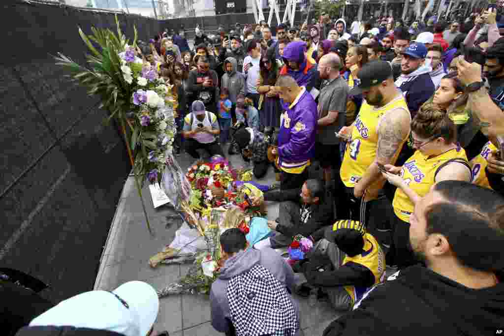 Fans of Kobe Bryant mourn at a memorial to him in front of Staples Center, home of the Los Angeles Lakers, after word of the Lakers star&#39;s death in a helicopter crash, in downtown Los Angeles, Jan. 26, 2020. 