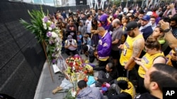 Fans of Kobe Bryant mourn at a memorial to him in front of Staples Center, home of the Los Angeles Lakers, after word of the Lakers star's death in a helicopter crash, in downtown Los Angeles, Jan. 26, 2020. 