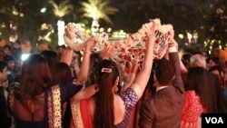 Brides arrive beneath a canopy of flowers for the wedding ceremony. (A. Pasricha/VOA)