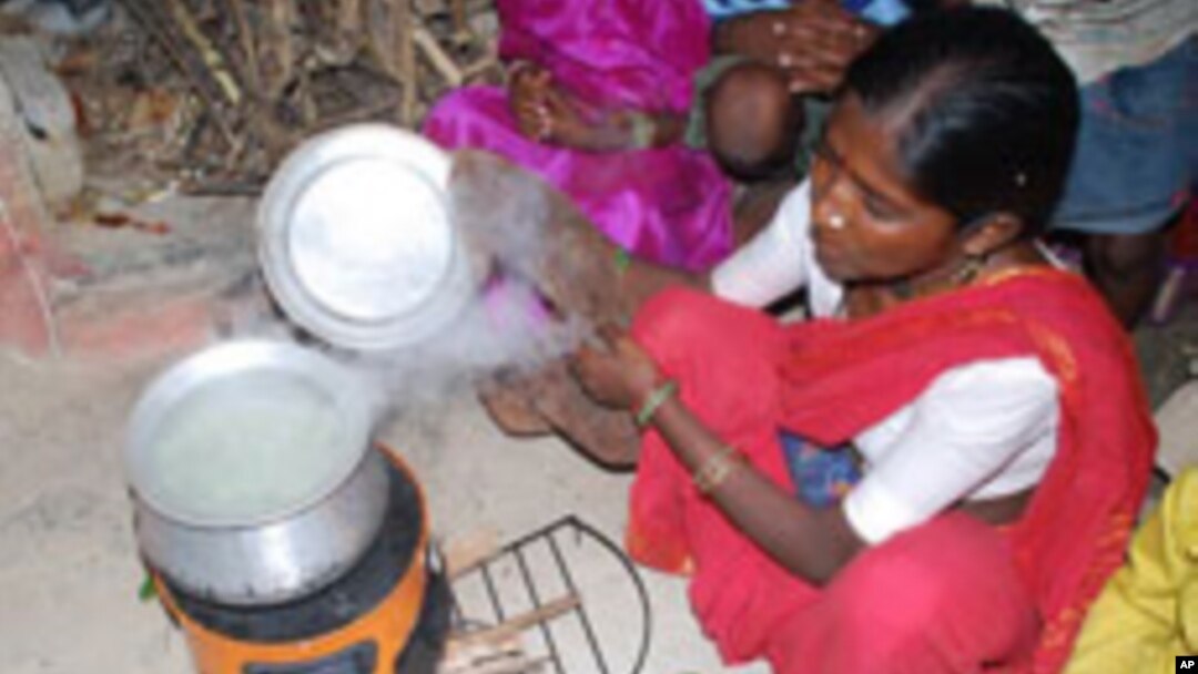FILE - A woman in India is uses a cookstove that produces less smoke for burning wood or any other fuel. 