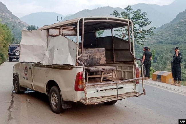 Petugas keamanan berdiri di dekat kendaraan polisi yang rusak di lokasi ledakan bom, di Malam Jabba di distrik Swat, provinsi Khyber Pakhtunkhwa, 22 September 2024. (Mehboob UL HAQ / AFP)