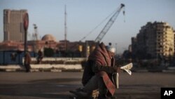 میسریه‌ک له‌ شوێنێـکی مه‌یدانی ته‌حریر دانیشـتووه‌ ڕۆژنامه‌یه‌ک ده‌خوێنێته‌وه‌، سێشه‌ممه‌ 8 ی دووی 2011