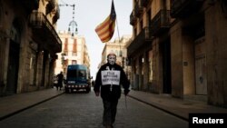 Un hombre con una máscara de Guido Fawkes porta una estelada, la bandera proindependencia catalana, mientras camina el jueves hacia una protesta contra un operativo policial en Barcelona.