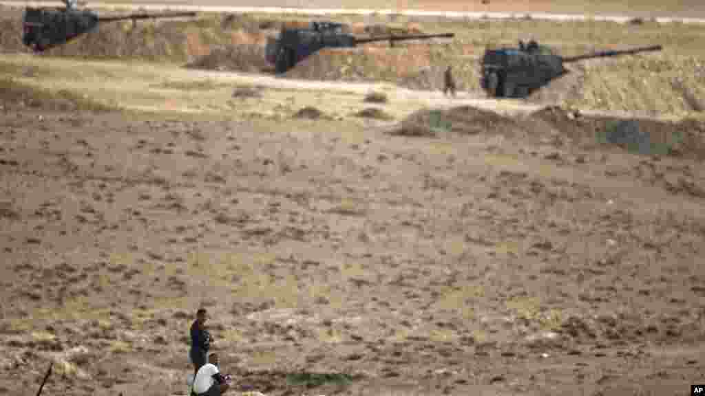 Người Kurd phía bên kia biên giới theo dõi cuộc chiến ở thị trấn Kobani từ một đỉnh đồi ở ngoại ô Suruc, Thổ Nhĩ Kỳ. 
