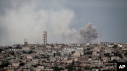 FILE - Smoke rises after a TNT bomb was thrown from a helicopter, hitting a rebel position during heavy fighting between troops loyal to Syrian President Bashar al-Assad and opposition fighters, near Kafr Nabuda, Idlib province, Syria, Sept. 19, 2013.