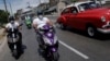 Motards transportant de la nourriture pour les personnes vulnérables dans le cadre des mesures prises par le gouvernement cubain pour lutter contre le COVID-19, La Havane, 1er avril 2020. (Reuters/Alexandre Meneghini)