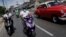 Motards transportant de la nourriture pour les personnes vulnérables dans le cadre des mesures prises par le gouvernement cubain pour lutter contre le COVID-19, La Havane, 1er avril 2020. (Reuters/Alexandre Meneghini)