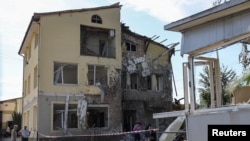 乌克兰利沃夫郊区居民查看俄罗斯无人机袭击后房屋的损坏情况。(2024年6月19日)