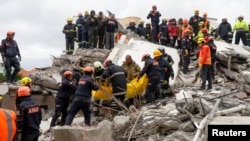 Emergency personnel carry a body during a search for survivors in a collapsed building in Durres, Nov. 28, 2019, after an earthquake shook Albania.