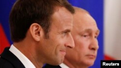 French President Emmanuel Macron, left, and Russian President Vladimir Putin attend a signing ceremony after talks in St. Petersburg, May 24, 2018. 