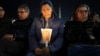 A woman holds a candle as Cardinal Robert Francis Prevost, Prefect of the Dicastery for Bishops, leads the recitation of the Holy Rosary for Pope Francis' health in St Peter's Square at the Vatican, March 3, 2025. 