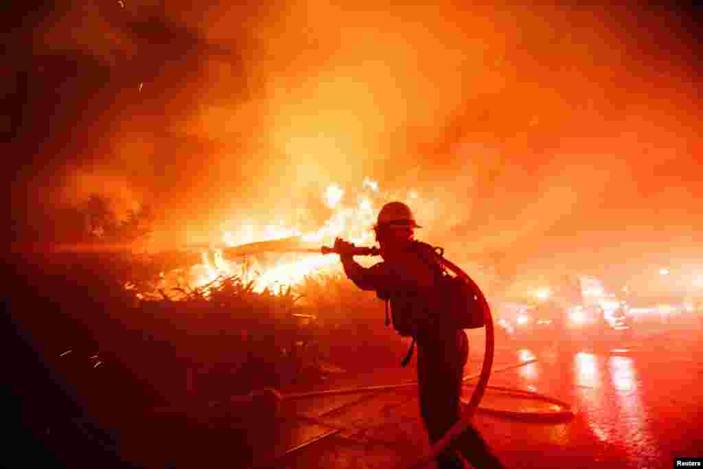 Un bombero lucha contra el incendio de Palisades durante una tormenta de viento en el lado oeste de Los Ángeles, California, el 7 de enero de 2025.