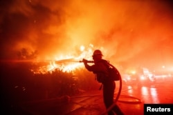 Vatrogasac se bori sa požarom Palisades, koji se ubrzano širi pod jakim vjetrom, na zapadnoj strani Los Angelesa, Kalifornija, 7. januara 2025.