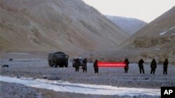 Tentara China merentangkan spanduk bertuliskan "Anda telah melewati garis perbatasan. Silakan mundur" di Ladakh, India (5/5). India dan China telah sepakat mengakhiri ketegangan yang telah berlangsung selama tiga minggu terkait sengketa wilayah perbatasan di Himalaya ini.