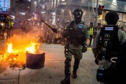 Police clear a road around a fire that was lit during a pro-democracy protest in the Mong Kok district of Hong Kong on May 27, 2020, as the city’s legislature debates over a law that bans insulting China's national anthem.