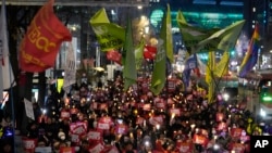 Manifestantes marchan hacia la oficina presidencial después de una vigilia con velas contra el presidente surcoreano, Yoon Suk Yeol, en Seúl, Corea del Sur, el jueves 5 de diciembre de 2024. AP