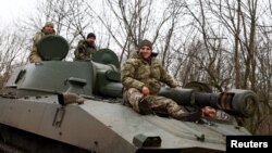 Militares ucranianos se trasladan en un obús autopropulsado 2C1 a lo largo de una carretera cerca de la ciudad de primera línea de Bájmut en medio del ataque de Rusia a Ucrania, región de Donetsk, Ucrania 8 de marzo de 2023. REUTERS/Lisi Niesner