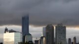 Low clouds surround the top of the One World Trade Center tower, center left, at sunrise during the 14th anniversary of the terrorist attacks, Sept. 11, 2015.