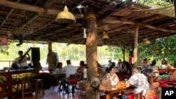File - People sit at a restaurant at Anjuna in Goa, India, Dec.12, 2020, as coronavirus is sapping Goa's vibrant beach shacks and noisy bars of their lifeblood where usually its tourism-led economy booms with foreign travelers at this time of the year.