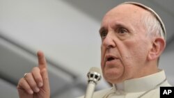 Pope Francis answers reporters questions during a news conference aboard the papal flight on the journey back from Brazil, July 29, 2013. 