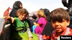 A family fleeing the violence in Mosul, Iraq, waits at a checkpoint in the country’s Kurdistan region on June 11, 2014. 