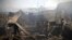 Men take photos of the ruins left after a fire devastated an electronic appliances market in Kabul, Afghanistan, Nov. 2, 2018. Residents of the Afghan capital are grappling with the aftermath of a massive blaze that destroyed hundreds of stores at a market in Kabul.