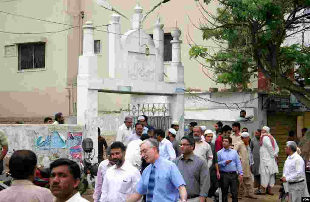 نماز جنازہ کی ادائیگی کے بعد مسجد سے باہر آتے افراد