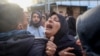 TOPSHOT - A woman reacts during the funeral of members of the press who were killed in an Israeli strike, at the al-Awda Hospital in the Nuseirat refugee camp in the central Gaza Strip, on December 26, 2024.