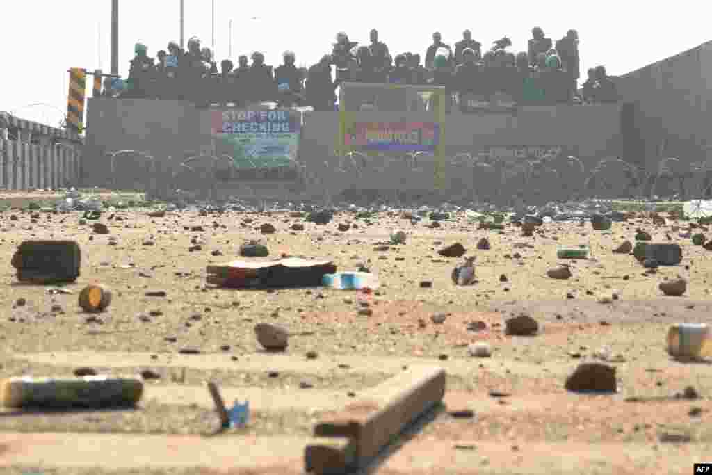 Police in riot gear and Rapid Action Force (RAF) personnel block a highway to stop farmers from marching towards New Delhi as they protest to demand minimum crop prices, near the Punjab-Haryana state border at Shambhu in Patiala district.