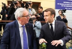 FILE - France's President Emmanuel Macron, right, and President of the European Commission Jean-Claude Juncker speak during the informal meeting of European Union leaders in Sibiu, Romania, May 9, 2019.