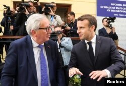 FILE - France's President Emmanuel Macron, right, and President of the European Commission Jean-Claude Juncker speak during the informal meeting of European Union leaders in Sibiu, Romania, May 9, 2019.