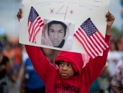 FILE - Jaylen Reese, 12, of Atlanta, marches during a protest of George Zimmerman's not guilty verdict in the 2012 shooting death of teenager Trayvon Martin, Atlanta, Georgia, July 15, 2013.
