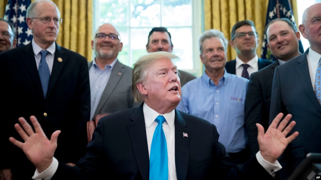 President Donald Trump, accompanied by Rep. Mike Conaway, R-Texas, left, Agriculture Secretary Sonny Perdue, right, and farmers and ranchers, speaks in the Oval Office of the White House, May 23, 2019, in Washington. 