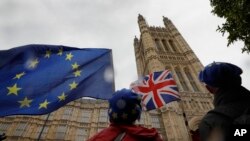 Demonstrators waves flags near Parliament in London, Oct. 17, 2019. 