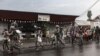 Members of the M23 armed group walk alongside residents through a street of the Keshero neighborhood in Goma, on Jan. 27, 2025. 