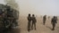 FILE - Cameroonian soldiers from the Rapid Intervention Brigade stand guard amidst dust kicked up by a helicopter in Kolofata, Cameroon, March 16, 2016. 