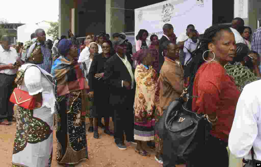 Voters queue up to cast their votes at a polling station as the country goes to the polls in Maputo, Mozambique, Oct. 15, 2014. 