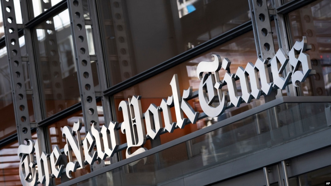 FILE - In this May 6, 2021 file photo, a sign for The New York Times hangs above the entrance to its building, in New York. 