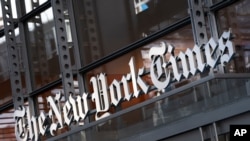 FILE - In this May 6, 2021 file photo, a sign for The New York Times hangs above the entrance to its building, in New York. 