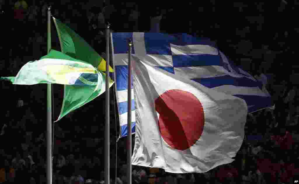 Bendera Brazil, Jepang dan Yunani berkibar dalam upacara penutupan Olimpiade Musim Panas 2016 di Rio de Janeiro, Brazil (21/8). (AP/Chris Carlson)