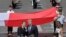 French President Emmanuel Macron talks with President Donald Trump next to a huge French flag after the Bastille Day parade in Paris, July 14, 2017. 