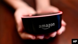 Un niño sostiene su Amazon Echo Dot en Kennesaw, Georgia, el 16 de Agosto de 2018. 