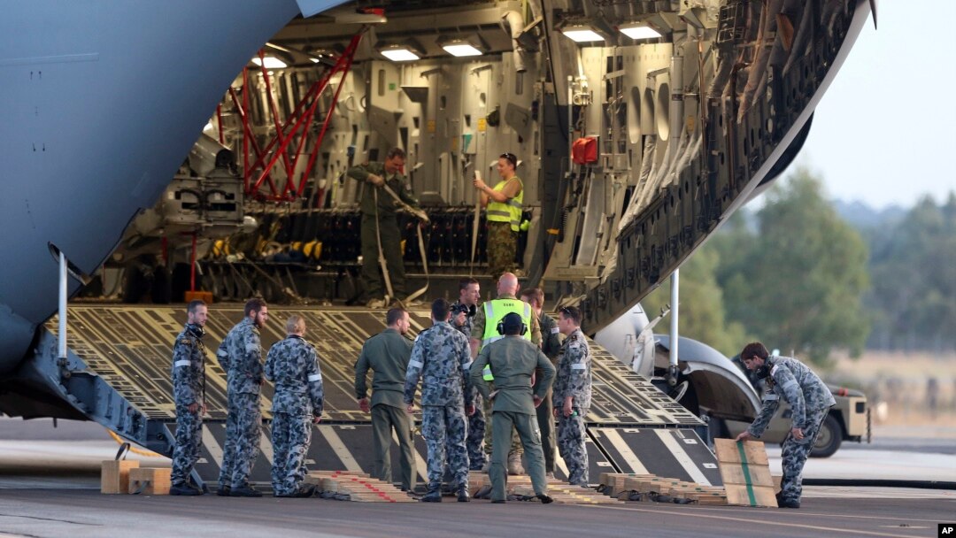 Para kru bersiap untuk mengeluarkan helikopter Sea Hawk dari pesawat Pasukan Kerajaan Australia C-17 sesaat setelah mendarat di Pangkalan Udara Militer RAAF Pearce di Perth, Australia (28/3), untuk membantu pencarian pesawat MH370 yang masih belum ditemukan hingga hari ini.