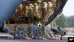 Para kru bersiap untuk mengeluarkan helikopter Sea Hawk dari pesawat Pasukan Kerajaan Australia C-17 sesaat setelah mendarat di Pangkalan Udara Militer RAAF Pearce di Perth, Australia (28/3), untuk membantu pencarian pesawat MH370 yang masih belum ditemukan hingga hari ini.