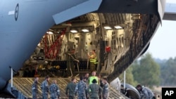 Kru bersiap menurunkan helikopter Sea Hawk dari Royal Australia Air Force C-17 setelah mendarat di RAAF Base Pearce untuk membantu pencarian pesawat Malaysia Airlines di Perth, Australia, 28 Maret 2014. 