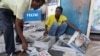 Vendors arrange copies of newspapers following the death of Tanzania's President John Magufuli in Dar es Salaam, March 18, 2021.