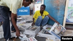 Vendors arrange copies of newspapers following the death of Tanzania's President John Magufuli in Dar es Salaam, March 18, 2021.