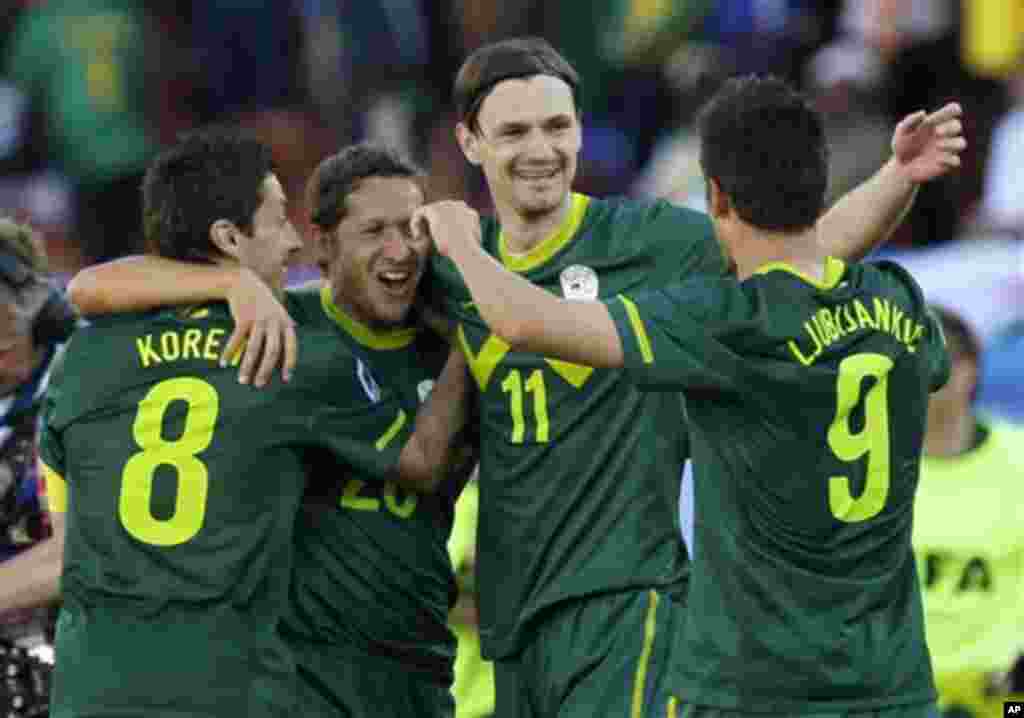 Slovenia's Robert Koren, left, celebrates with his teammates Zlatan Ljubijankic, right, Milivoje Novakovic, second from right, and Andrej Komac, second left, after scoring the winning goal during the World Cup group C soccer match between Algeria and Slov